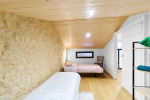a room with two beds and a stone wall at Logement Pascal in Villeneuve-sur-Lot
