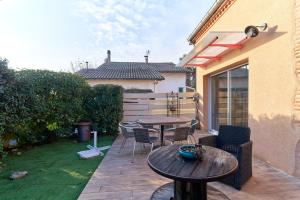 a patio with a table and chairs and a table at Logement Pascal in Villeneuve-sur-Lot