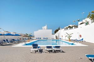 a swimming pool with two chairs and a swimming pool at Casa Begines in Vejer de la Frontera