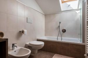 a bathroom with a toilet and a tub and a sink at Mongaduierhof Apt Schlern in Fie allo Sciliar +22 photos