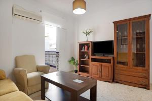 a living room with a couch and a tv at Casa Begines in Vejer de la Frontera