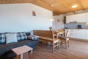 a living room with a couch and a table and a kitchen at Mongaduierhof Apt Schlern in Fie allo Sciliar