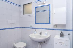 a white bathroom with a sink and a toilet at Appartamento Murena 1 in La Maddalena