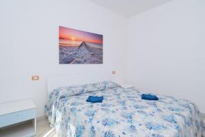 a bedroom with a bed and a picture on the wall at Appartamento Murena 1 in La Maddalena