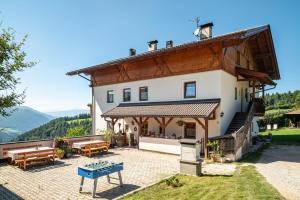 a large white house with a patio with tables at Mongaduierhof Apt Schlern in Fie allo Sciliar