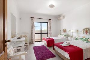 a white bedroom with two beds and a window at Casa da Oliveira in Loulé +22 photos