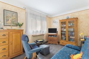 a living room with a blue chair and a tv at Sun Canigou in Vernet-les-Bains
