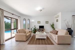 a living room with two couches and a coffee table at Casa da Oliveira in Loulé