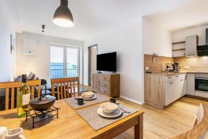 a kitchen and living room with a table and a dining room at Snorrum Wohnung 7 in Husby