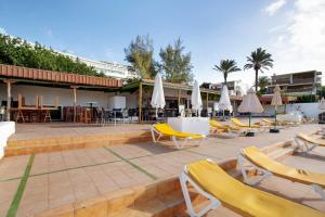 a patio with yellow chairs and tables and umbrellas at Vista Roja in San Agustin