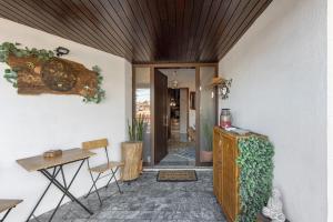 a living room with a table and a wooden ceiling at Sobreiro22 in Lourosa