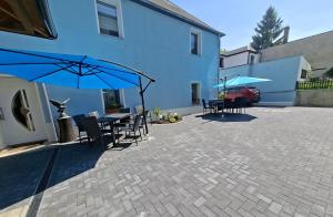 a patio with a table and chairs and umbrellas at Ferienwohnung Blumen in Radeberg