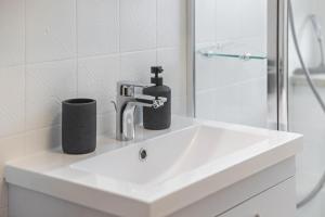 a white bathroom sink with a soap dispenser on it at Fewo mit Bergblick, Pool, Sauna in Oberaudorf +21 photos