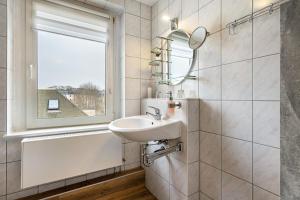 a bathroom with a sink and a window at Ferienwohnung Blumen in Radeberg +35 photos