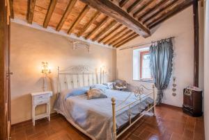 a bedroom with a bed and a table and a window at Glicine in Montieri
