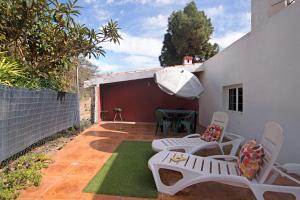 a patio with a table and chairs and an umbrella at Vivienda V Torres 1 in Vega de San Mateo