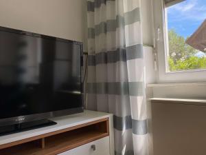 a flat screen tv sitting on a table next to a window at Bei Dörflingers in Klettgau