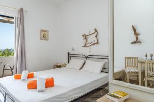 a white bedroom with a bed and a mirror at Perasma Studio 1a in Kipri