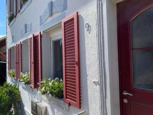 a row of red shuttered windows on a building at Bei Dörflingers in Klettgau