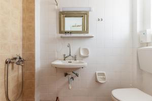 a bathroom with a sink and a toilet and a mirror at Perasma Studio 1a in Kipri