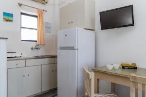 a kitchen with a white refrigerator and a table at Perasma Studio 1a in Kipri +12 photos