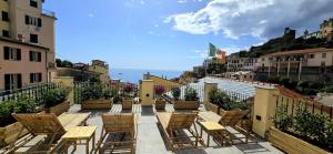 a row of chairs and tables on a balcony at Cinque Terre Homes by Bluchalet in Riomaggiore