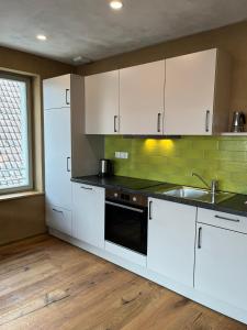 a kitchen with white cabinets and a sink at Bio Bausewein - No.2 Apartment in Iphofen