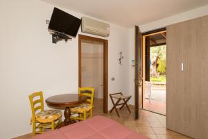 a living room with a table and chairs and a television at Il Girasole - Cappero in Venturina Terme