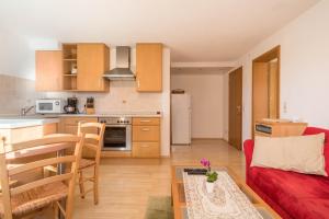 a kitchen and a living room with a red couch at Ferienwohnung Marschall in Achberg