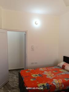 a bedroom with a bed with an orange blanket at 2 rooms, 2 balconies in Marsa Alam City