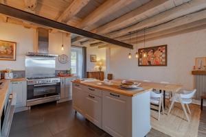 a kitchen with white cabinets and a wooden table at La Dordogne en Périgord in Salagnac
