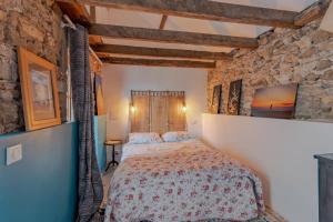 a bedroom with a bed and a stone wall at La Dordogne en Périgord in Salagnac +25 photos