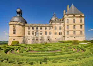 a castle with a garden in front of it at La Dordogne en Périgord in Salagnac