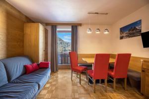 a living room with a couch and a table and chairs at Rosalpina Apt 4 in San Vigilio Di Marebbe