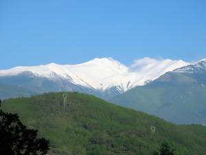 two giraffes standing on a hill with snow covered mountains at Le Mas in Arles-sur-Tech +3 photos