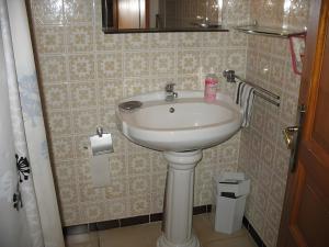 a bathroom with a white sink and a mirror at Le Mas in Arles-sur-Tech