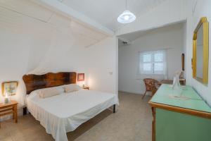 a bedroom with a white bed and a desk at Casa Cantina Scalecci in Noto +32 photos