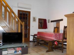 a living room with a table and a tv at Le Mas in Arles-sur-Tech
