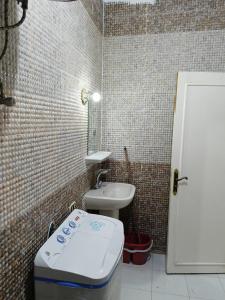 a small bathroom with a toilet and a sink at 2 rooms, 2 balconies in Marsa Alam City