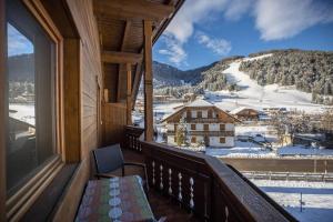 a balcony with a view of a snow covered mountain at Rosalpina Apt 4 in San Vigilio Di Marebbe