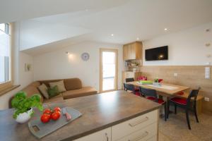a kitchen and living room with a table and a couch at Kristallhof Fewo Bergblick in Caldaro +11 photos