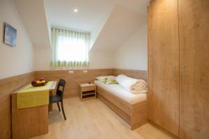 a small room with a bed and a desk at Kristallhof Fewo Bergblick in Caldaro