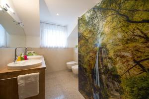 a bathroom with a sink and a shower curtain at Kristallhof Fewo Bergblick in Caldaro