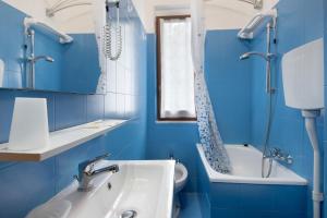 a blue bathroom with a sink and a toilet at Appartamento Monolocale Moneglia 25 in Moneglia +15 photos