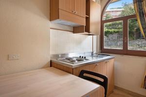 a small kitchen with a table and a window at Appartamento Monolocale Moneglia 25 in Moneglia