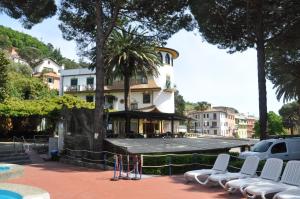 a building with white chairs in front of a building at Appartamento Monolocale Moneglia 25 in Moneglia