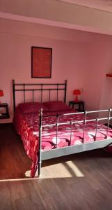 a bedroom with a bed with a red comforter at Chambres D'hôtes Le Bellevue - in Montbrun-les-Bains