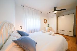 a bedroom with a large white bed with blue pillows at Villa Mar in Teià +26 photos