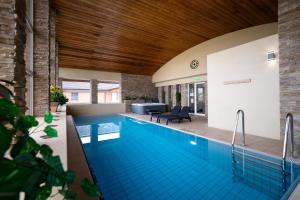 a large swimming pool in a house with a house at Hotel Garzon Plaza in Győr