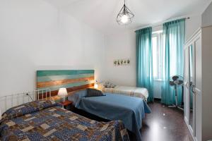 ein Hotelzimmer mit zwei Betten und einem Fenster in der Unterkunft Casa Rostan in Genua